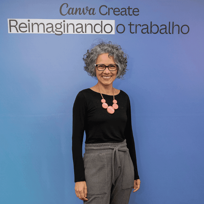 Canva Creator Andeira em frente ao painel escrito Canva Create Reimaginando o trabalho